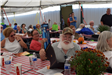 People sitting at tables inside large tent