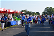 People walking on a paved lane lined by vendor tents