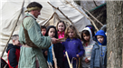 Man Talking to Group of Children Outdoors