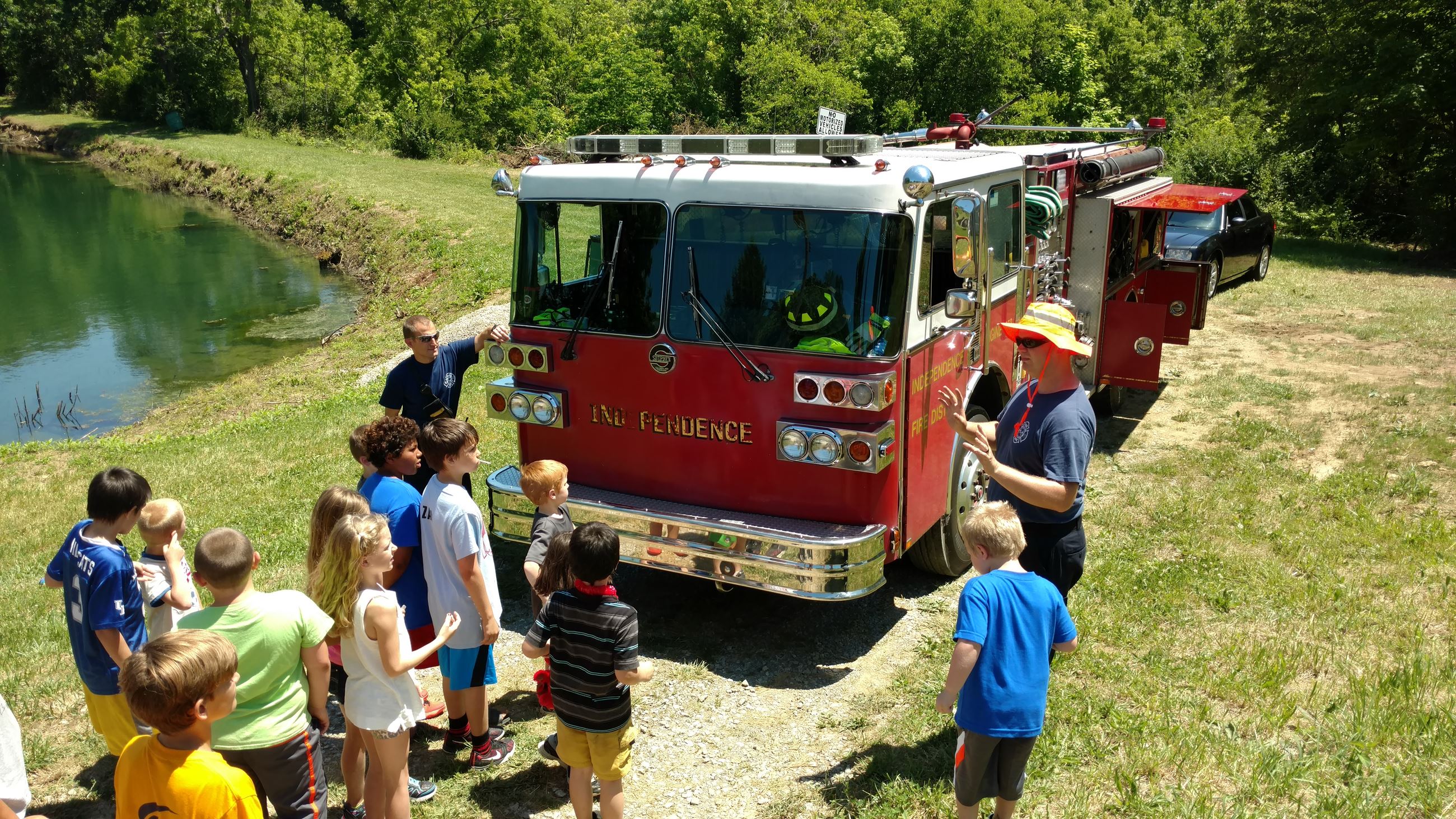 Firefighters talking to kids by a firetruck