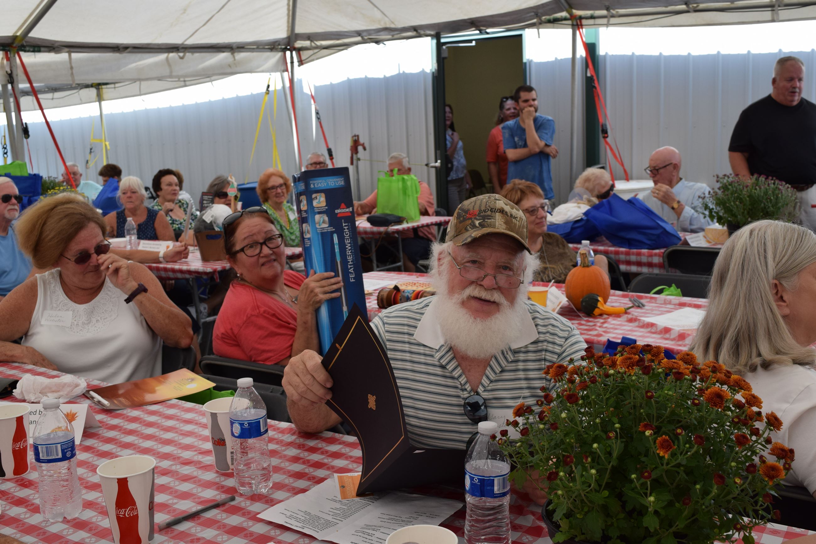 People sitting at tables inside large tent