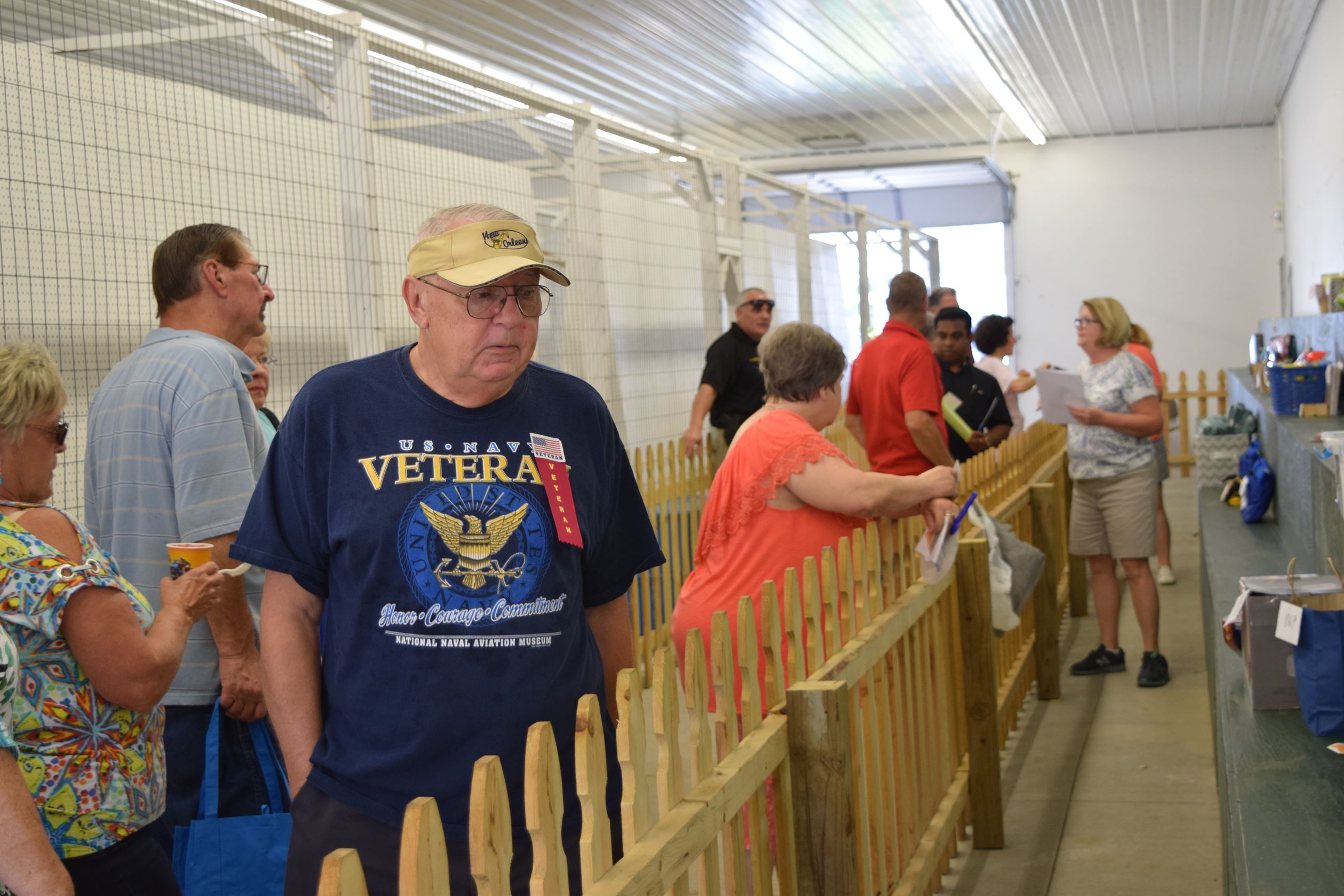People lined up by an indoor fence