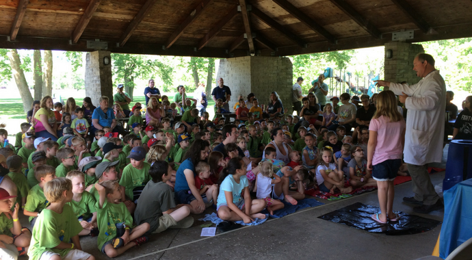 Man in Lab Coat Talking to Group of Children
