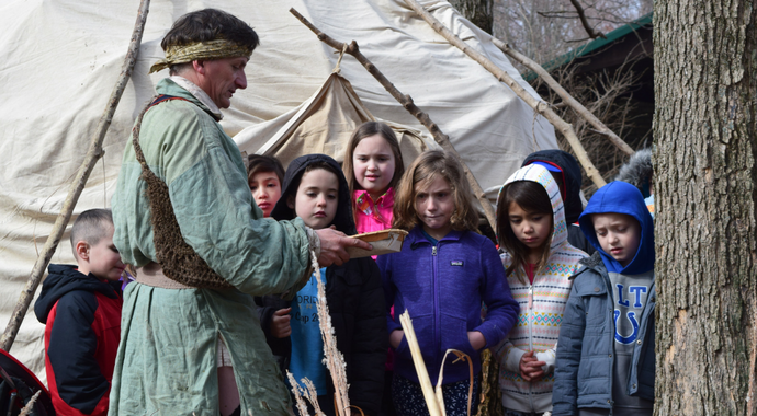 Man Talking to Group of Children Outdoors