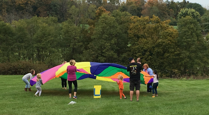 Kids and Adults Playing with Parachute